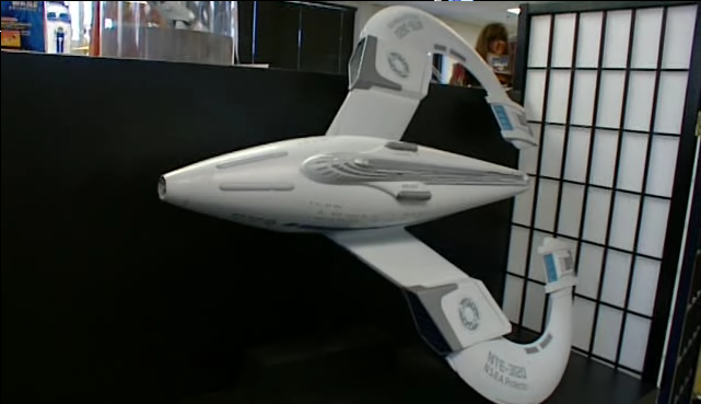 不大像 Star Trek 會有的太空船：梭型的機身，連往曲速引擎的翼是圓弧形的，而且沒有碟型艦