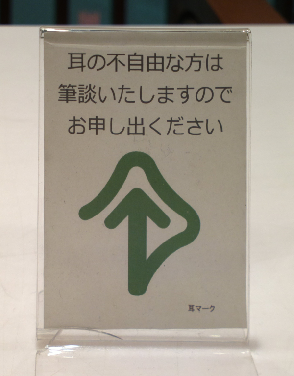 以日文跟綠色耳朵圖示說明此處可筆談的桌上立牌