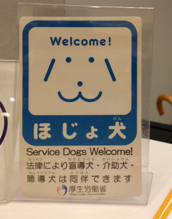 以日文及英文寫著歡迎各種協助犬進入該場所的桌面立牌