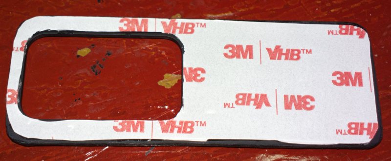 貼上 3M VHB™雙面膠的鏡頭滑蓋內面，印著「3M VHB™」的雛形紙還沒撕下