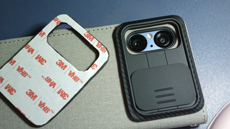 兩個移植自 Galaxy S20 的鏡頭滑蓋放在 Xperia 5Ⅴ保護殼上，其中一個開口對齊手機保護殼原本的鏡頭開口（前者略大於後者），另一個背面朝上顯露出自己裁切（而不平整）的 3M VHB 雙面膠。