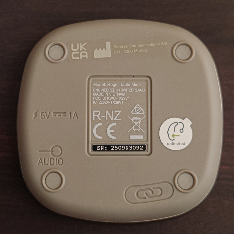 Roger Table Mic 3 底面特寫，有個安裝接收器授權的按鈕，以及一張圓形貼紙標示可安裝任意數量 (unlimited) 接收器授權